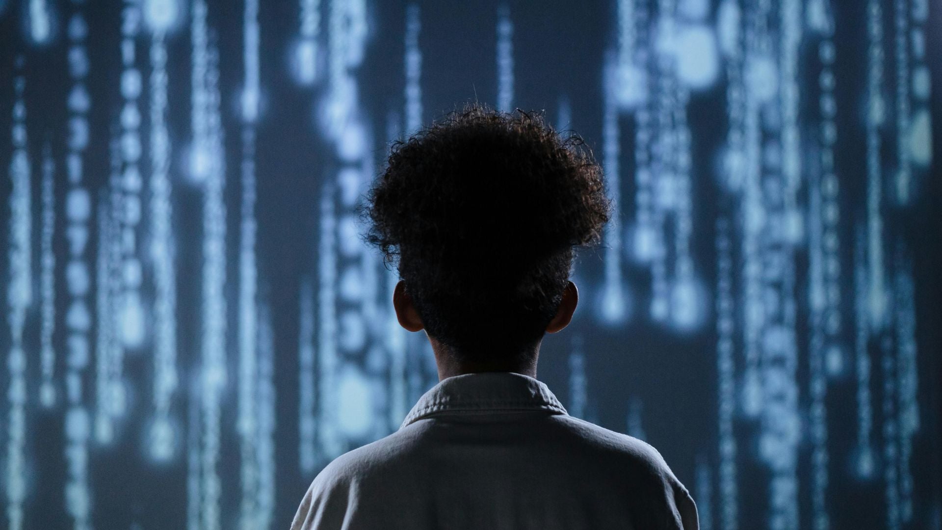 A child looking at some data being projected on a wall feeling overwhelmed by the amount of information there is